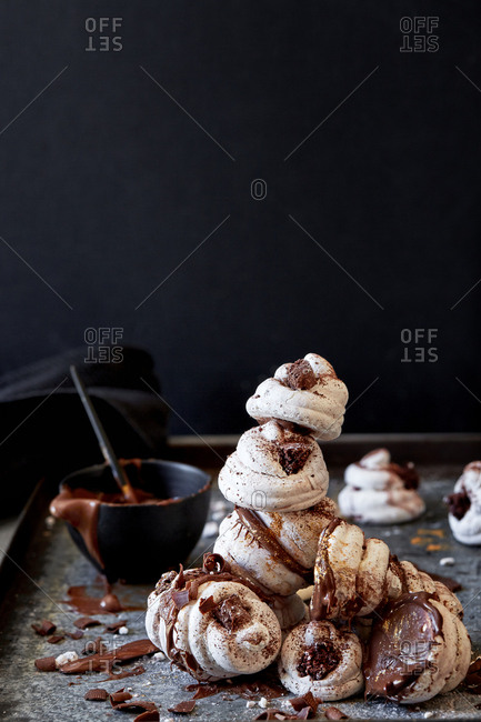 Small chocolate meringues on a baking tray with chocolate spread