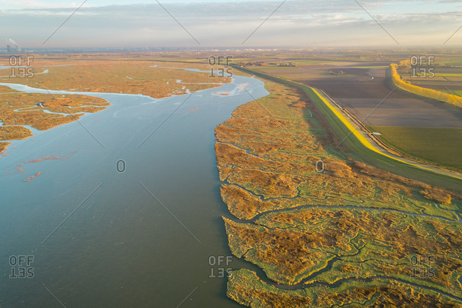Aerial view of a river passing between wetland ecosystem, Netherlands.