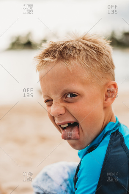 Portrait of boy sticking tongue out on a beach