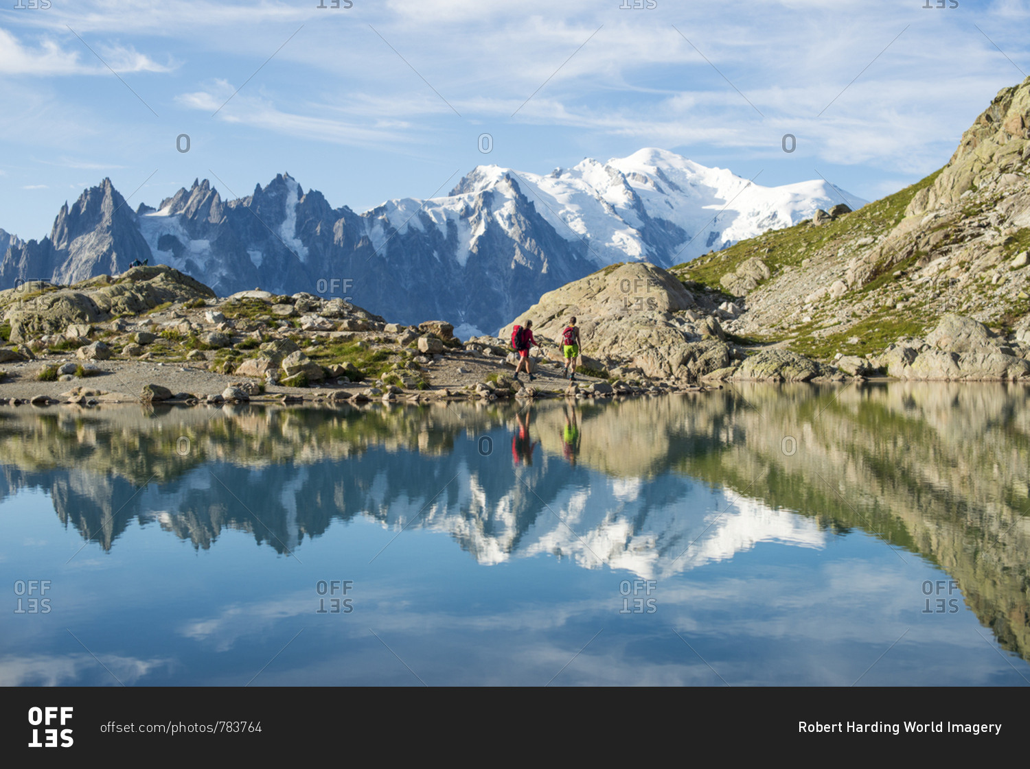 Hikers and the summit of Mont Blanc reflected in Lac Blanc on the Tour du Mont Blanc trekking route in the French Alps, Haute Savoie, Auvergne-Rhone-Alpes, France, Europe