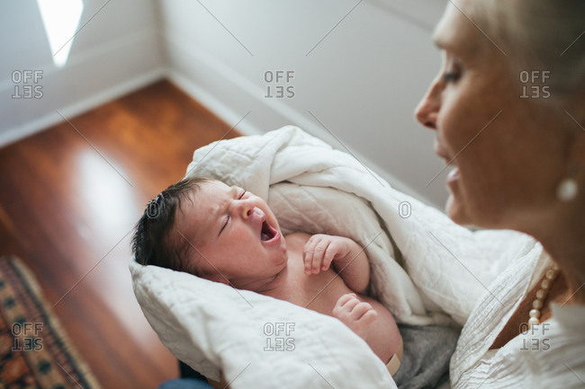 Yawning newborn in grandmother's lap