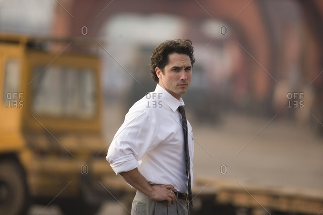 Portrait of a young adult businessman standing in a shipping yard.