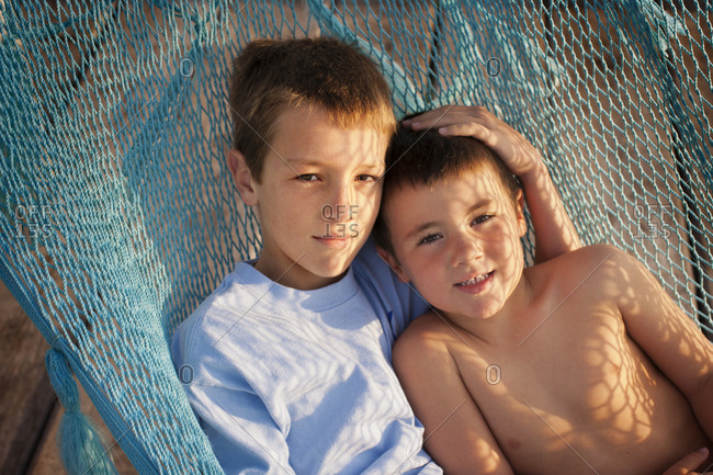 Portrait of two brothers lying in a hammock together.