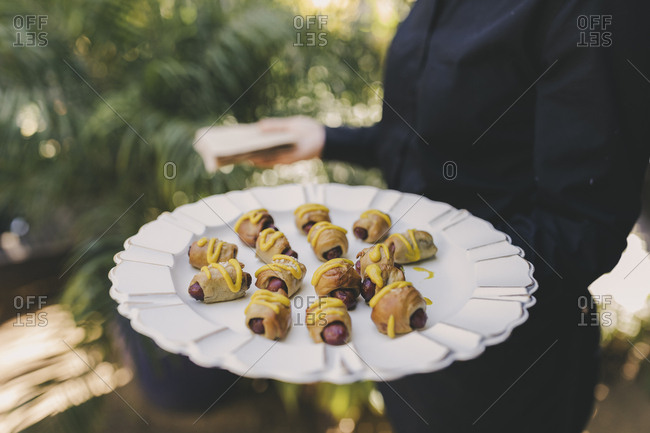 Woman serving wedding sausage appetizers