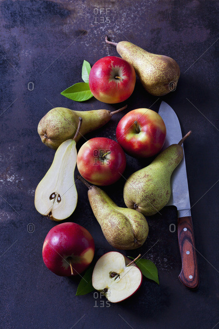 Sliced and whole apples and pears  on dark ground