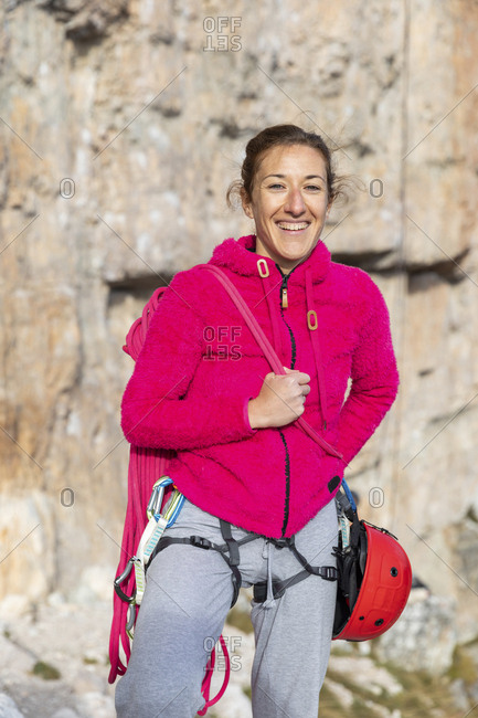Italy- Cortina d'Ampezzo- portrait of a happy woman with climbing equipment in the Dolomites mountains