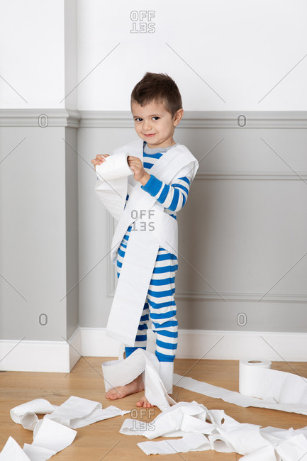 Young boy wrapping toilet paper around himself