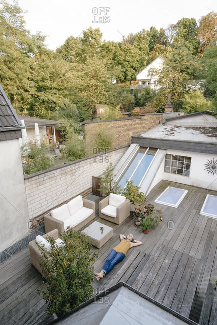 Woman relaxing on terrace listening music with headphones