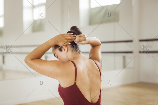 Rear view of ballerina adjusting hair
