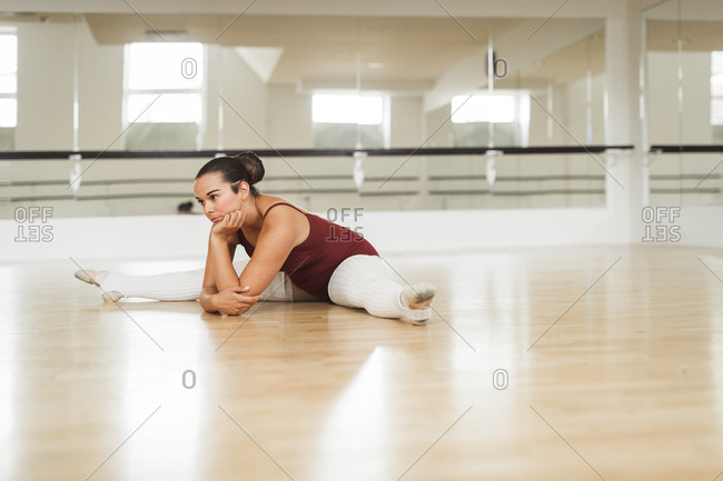 Ballerina stretching on wooden floor