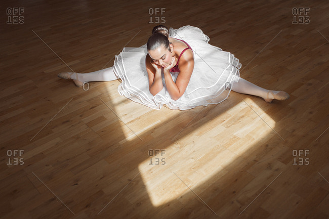 Ballerina stretching on wooden floor