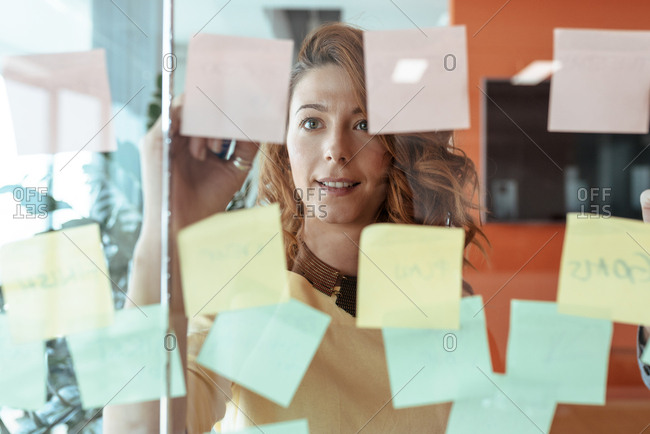 Colleagues brainstorming while writting down notes on stickers