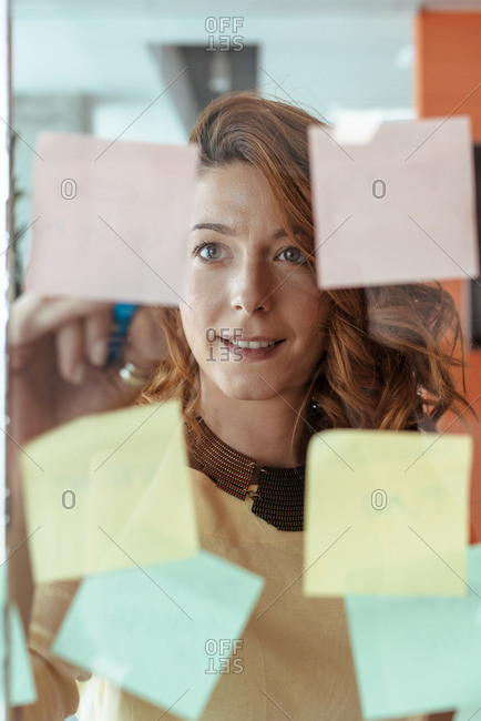 Colleagues brainstorming while writting down notes on stickers