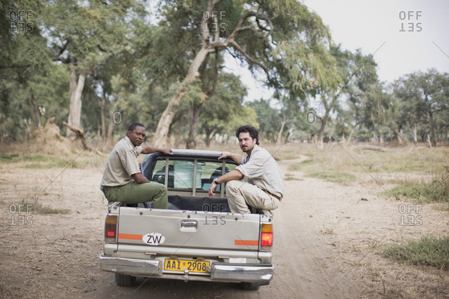 Men Riding In The Back Of A Van