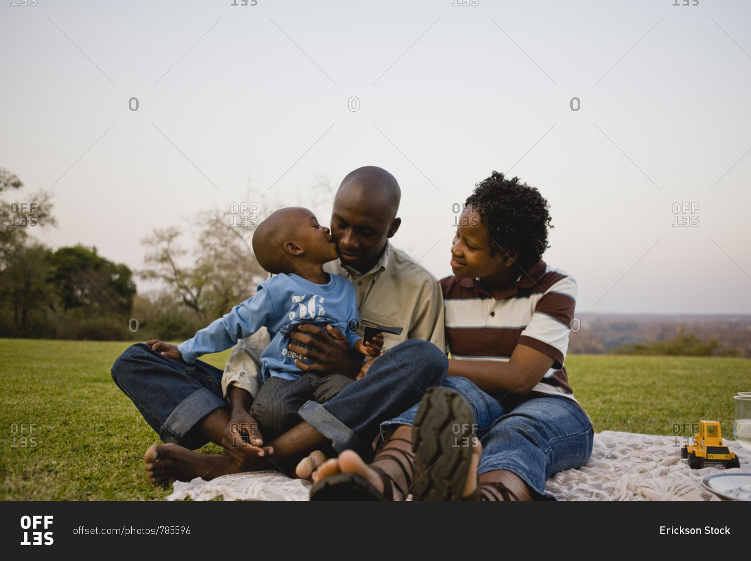 Young boy having a picnic with his young adult mother and father.