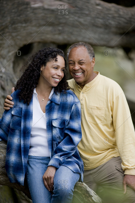 Couple sitting together on tree trunk