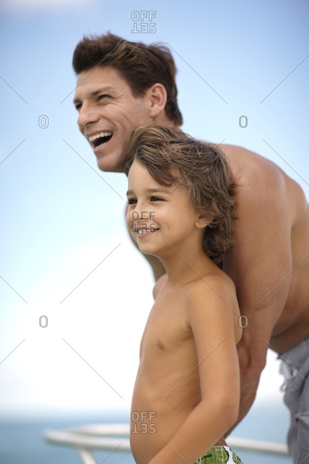 Smiling father and son on the deck of a boat.