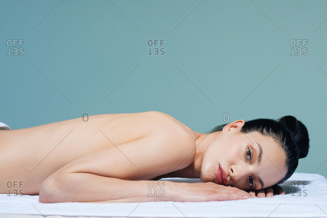 Beautiful Caucasian woman relaxing on massage table at wellness salon.