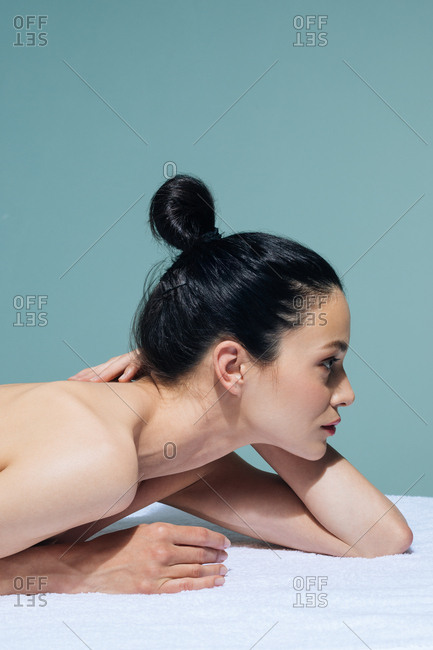 Beautiful Caucasian woman relaxing on massage table at wellness salon.