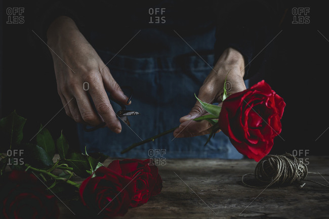 Unrecognizable woman making a bouquet of red roses for Valentine\'s Day. Love