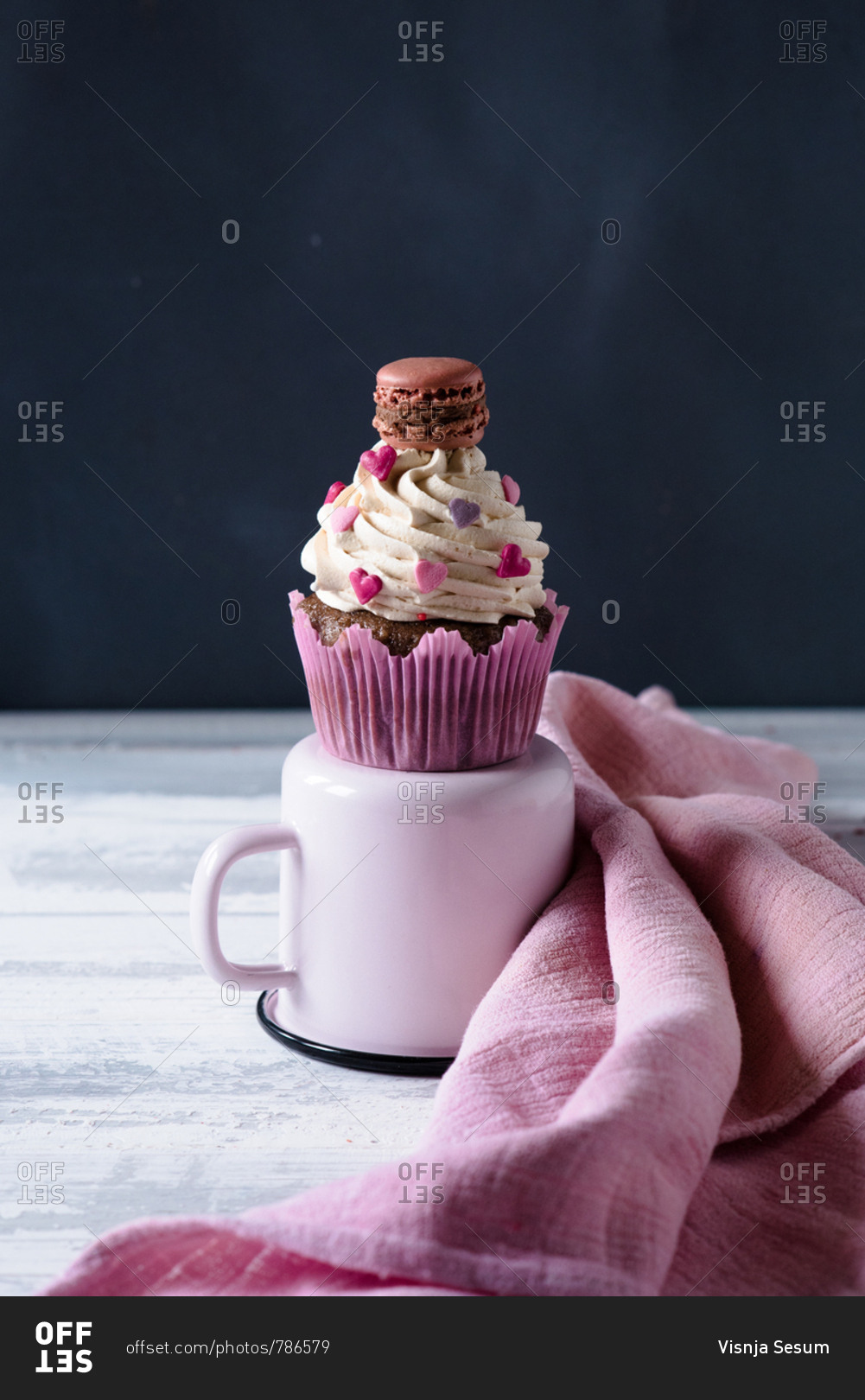 A Valentine's day themed cupcake with cream and hearts decoration