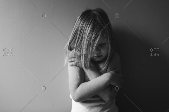 Little girl hugging herself