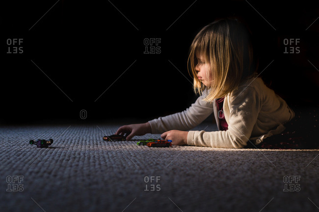 Little girl playing with toy cars