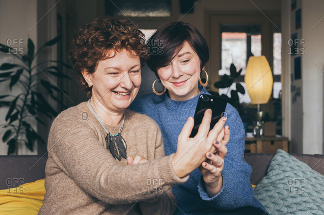 Candid moment, mother and daughter having fun taking a selfie at home