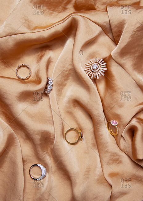 Collection of rings on a cascading orange satin fabric