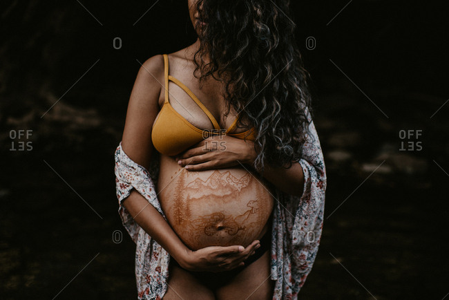 Pregnant woman with hands on baby bump