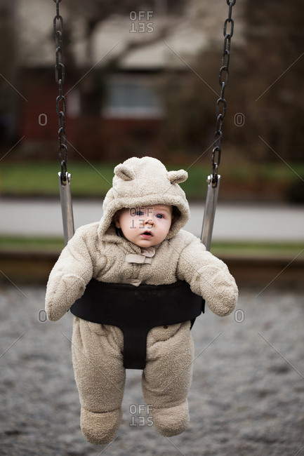 Baby in thick snowsuit in a swing