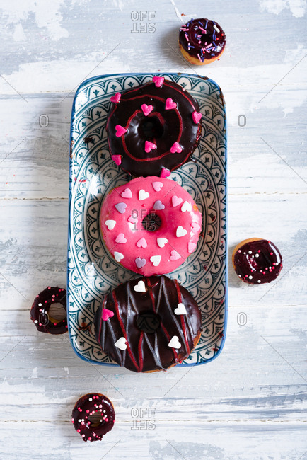 Valentines day themed donuts with pink and dark red glaze and hearts decorations