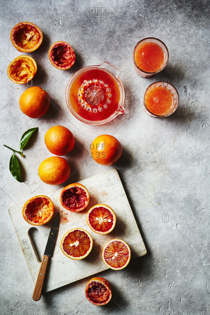 Blood oranges being cut up and squeezed into juice as a prep scene.