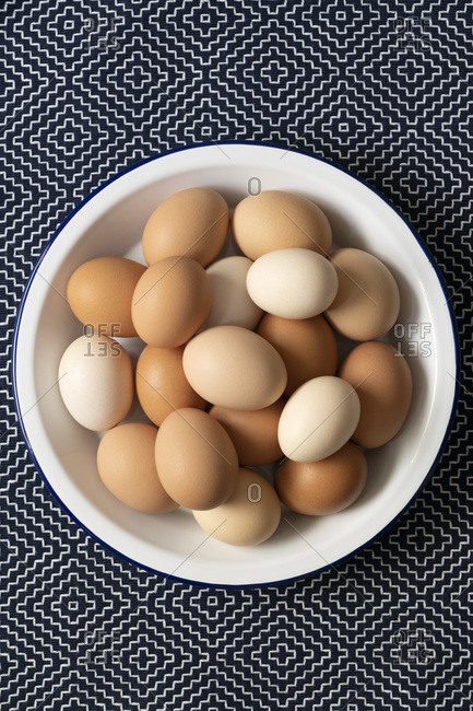 Brown, light brown and white eggs in a bowl.