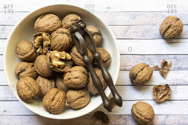 Cracked and whole walnuts in a bowl.