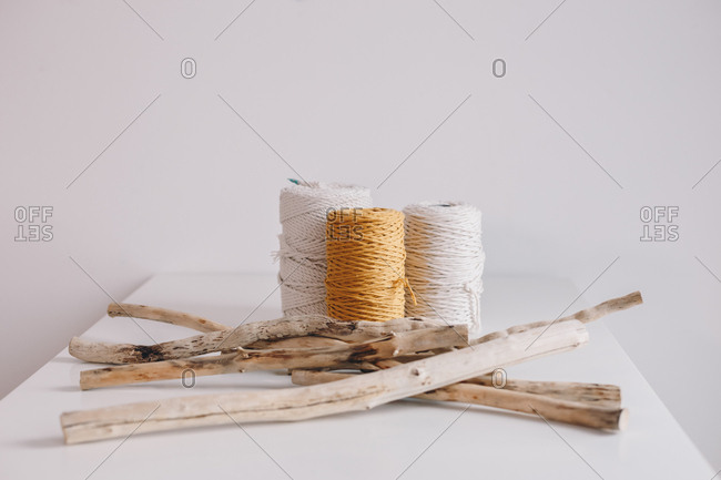 Detail shot of yarn balls and driftwood branches that are used for making macrame.