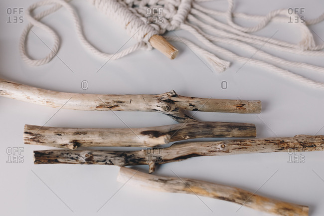 Detail shot of threads and driftwood branches that are used for making macrame.