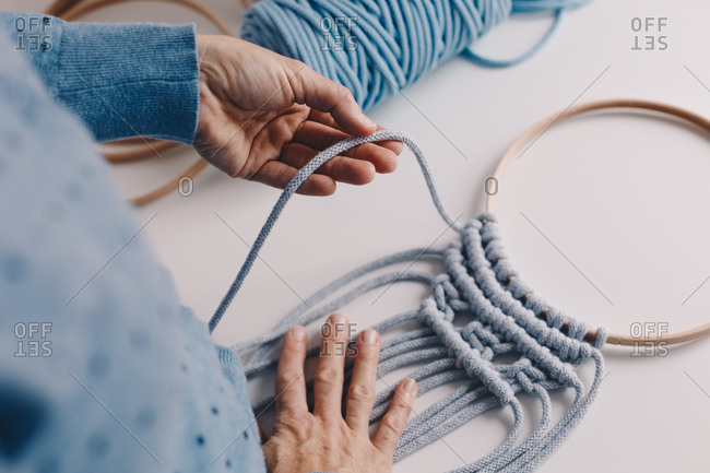 Detail shot of woman's hands making a macrame.