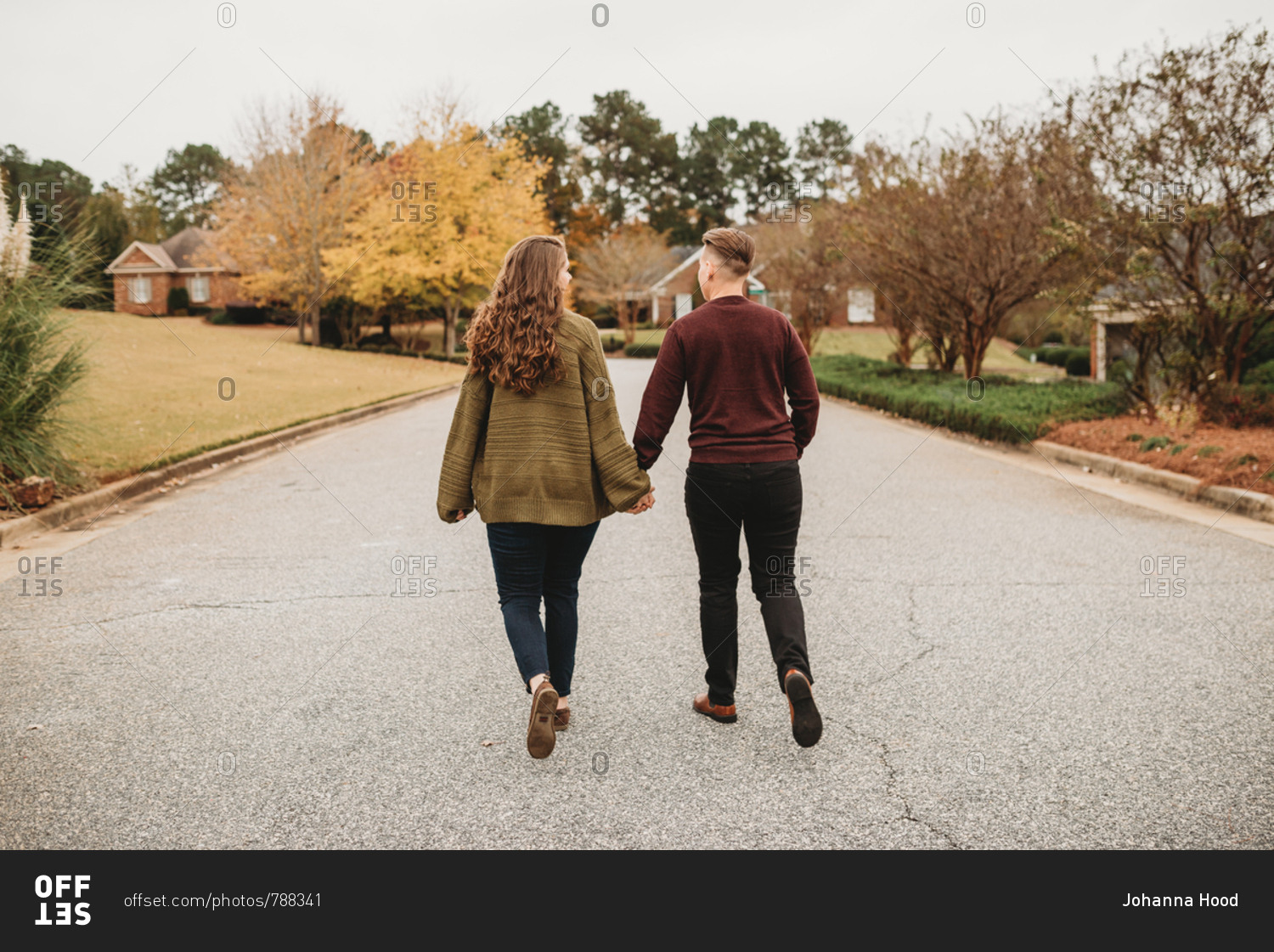 two people walking away holding hands