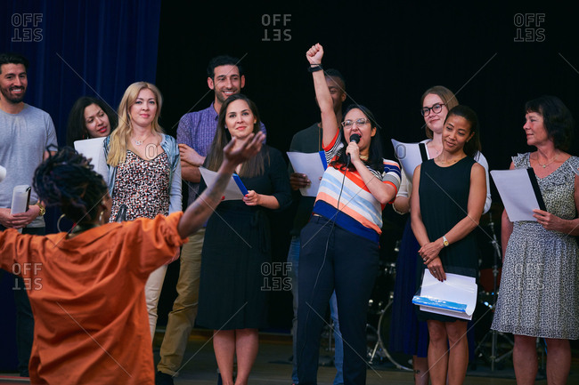 Choir singer with friends performing on stage in auditorium