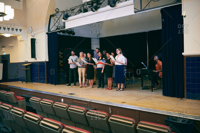 Friends with music sheets singing at choir practice