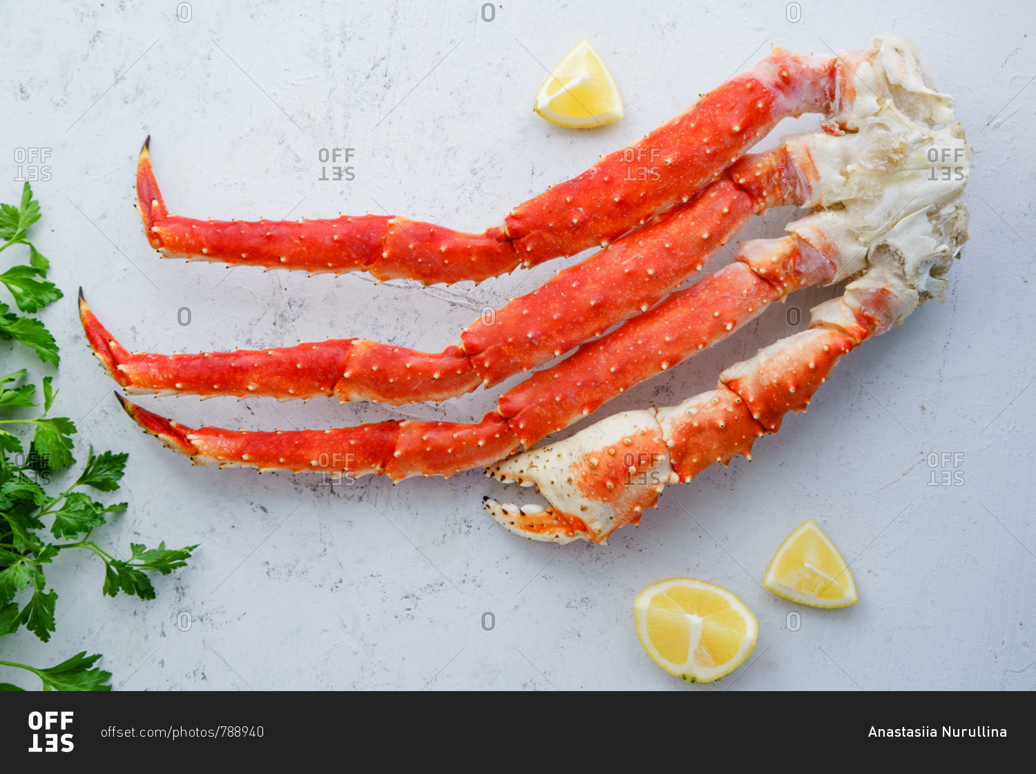Raw alaskan king crab legs with lemon and parsley