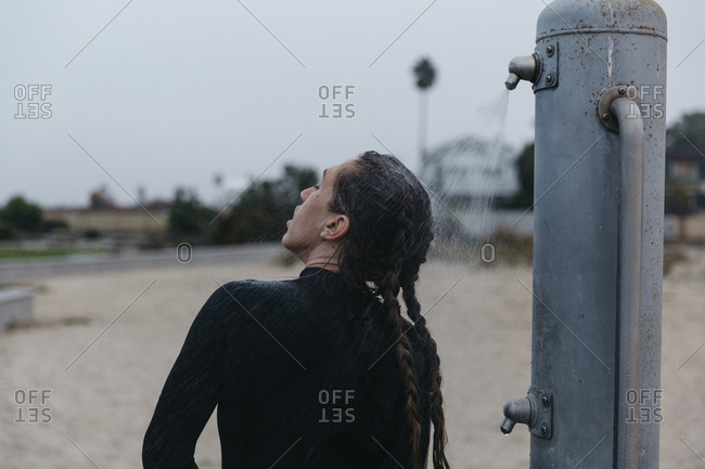 Rear View Of Woman With Braided Hair Taking Shower While Standing
