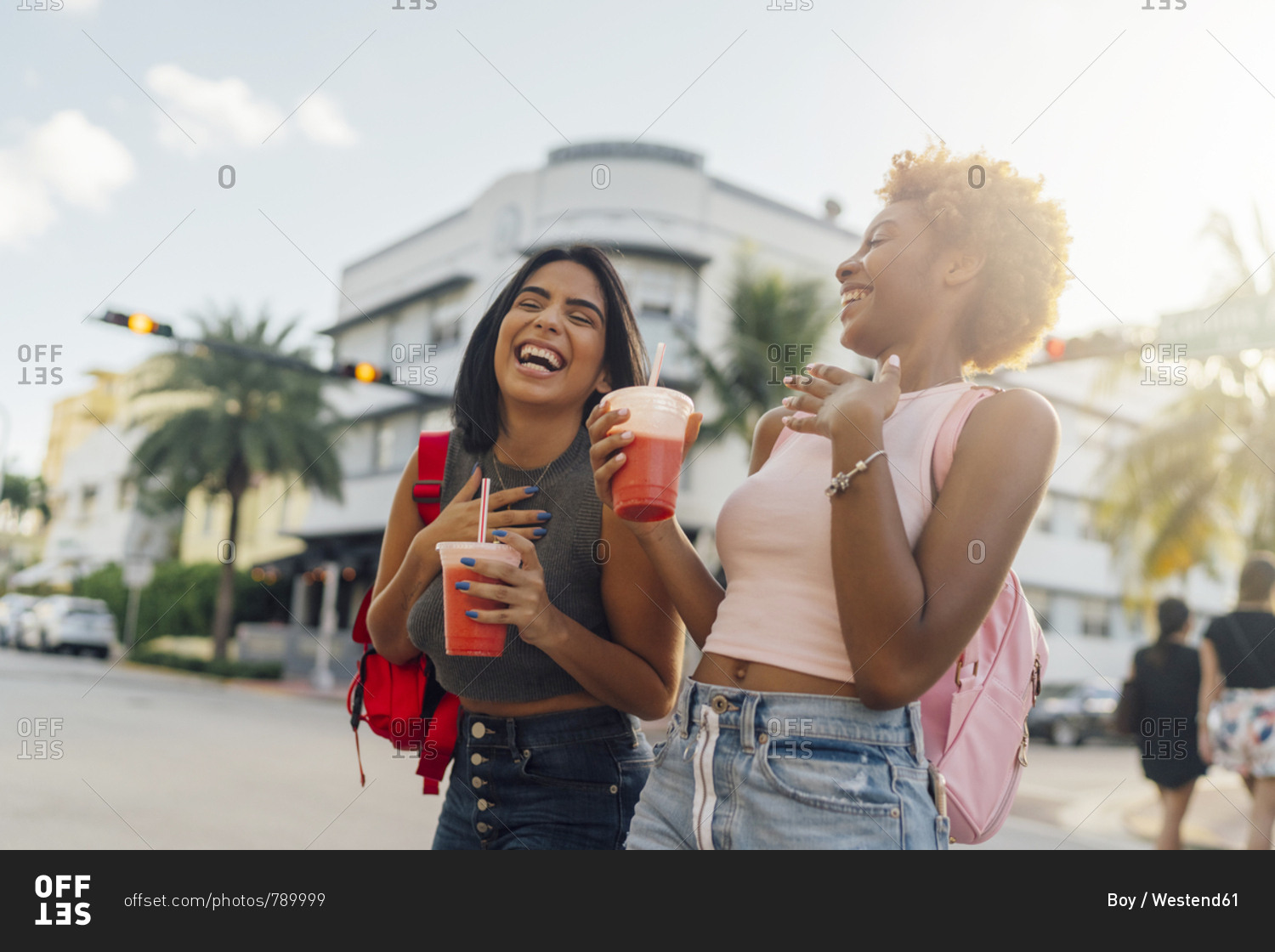 USA- Florida- Miami Beach- two happy female friends having a soft drink in the city