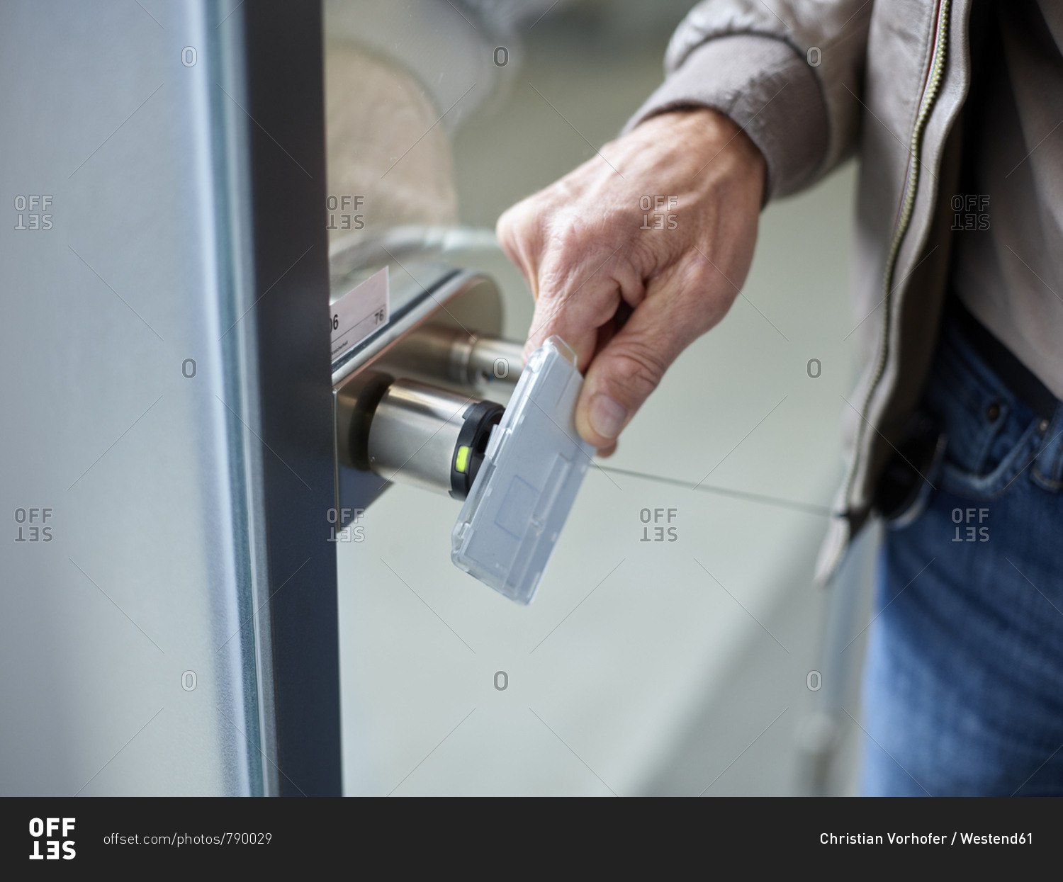 Close-up of businessman in office opening door with access card