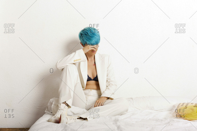 Grunge lesbian woman sitting pensive on bed