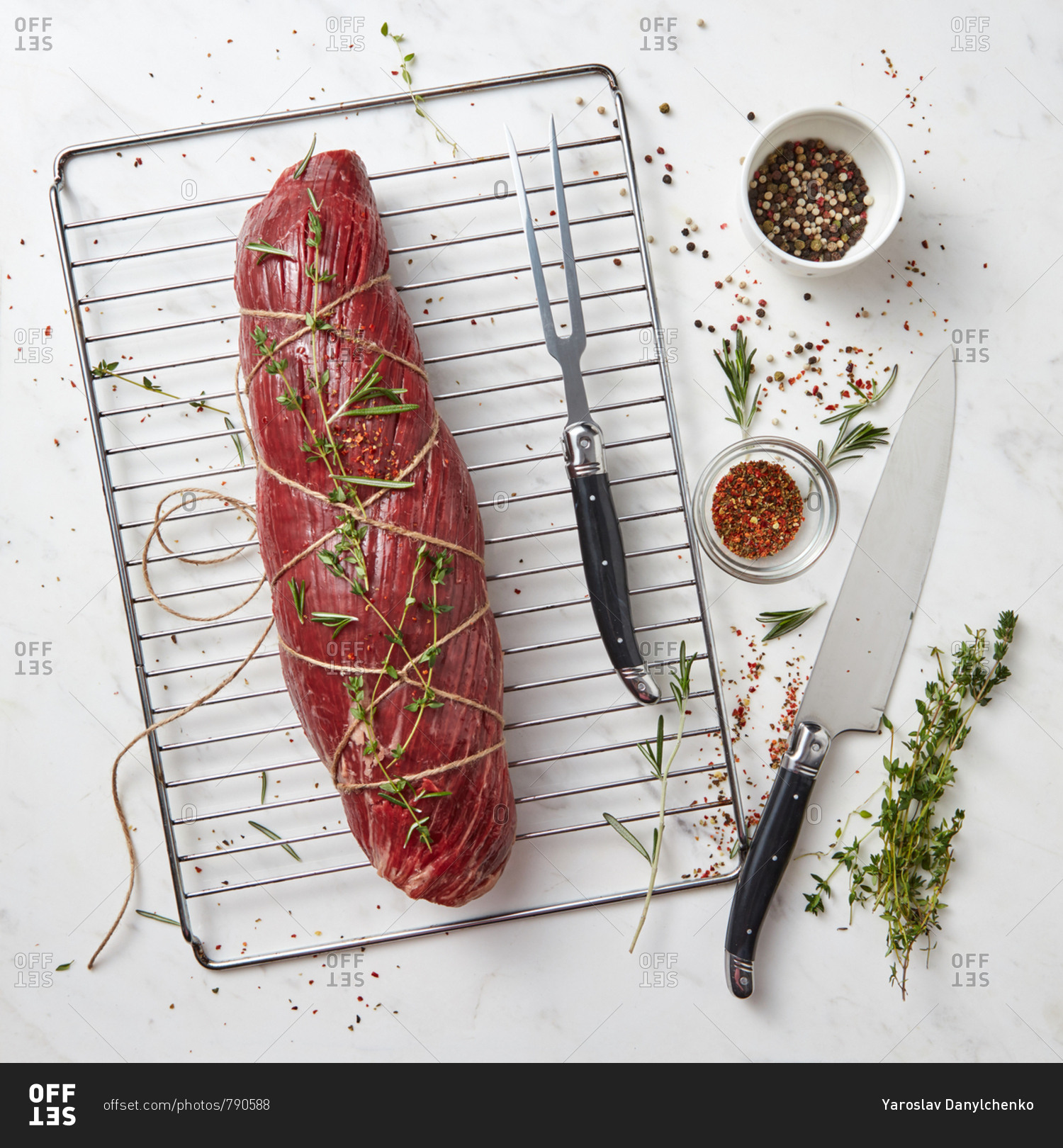 Fresh raw meat, whole piece of fillet with herbs and spices on a stone white background. Cooking ingredients for healthy organic meals. Top view.