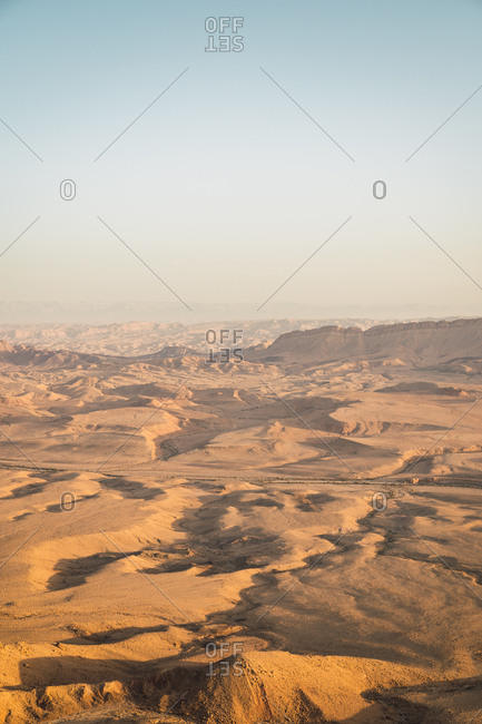 Perspective view of dry and hot Negev desert with sandy hills in sunny haze, Israel