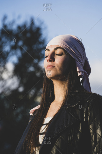 Cheerful young man wearing red bandana while looking away in city