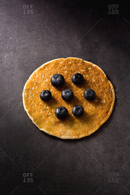 Closeup delicious pancake with ripe blueberries on dark gray tabletop